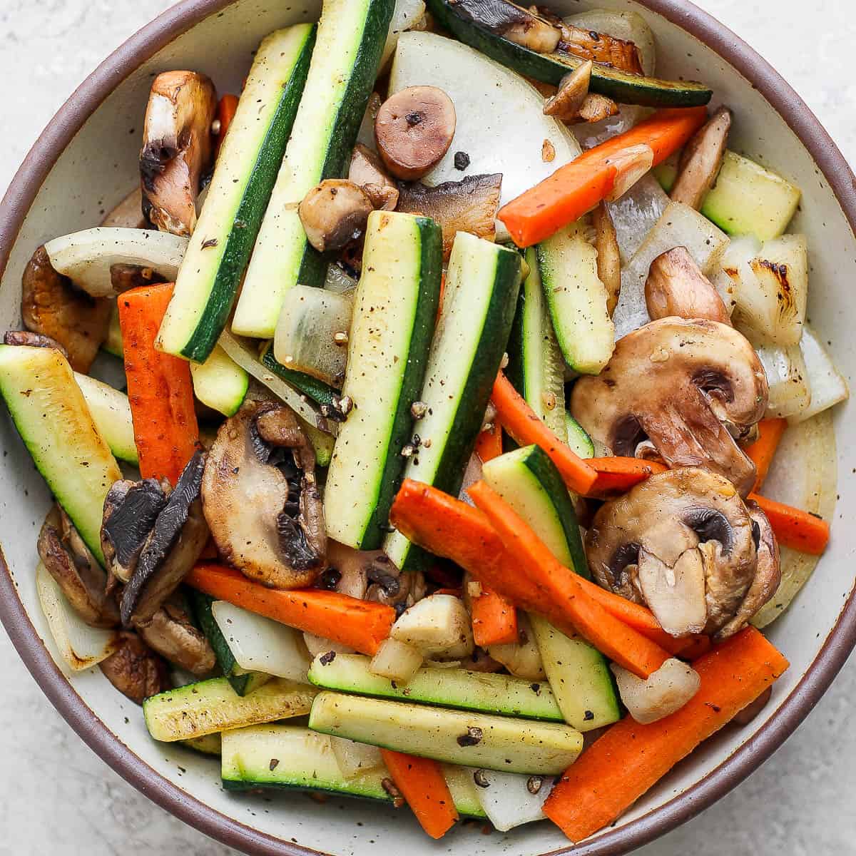 Top down shot of a bowl of hibachi vegetables with salt and pepper on top.