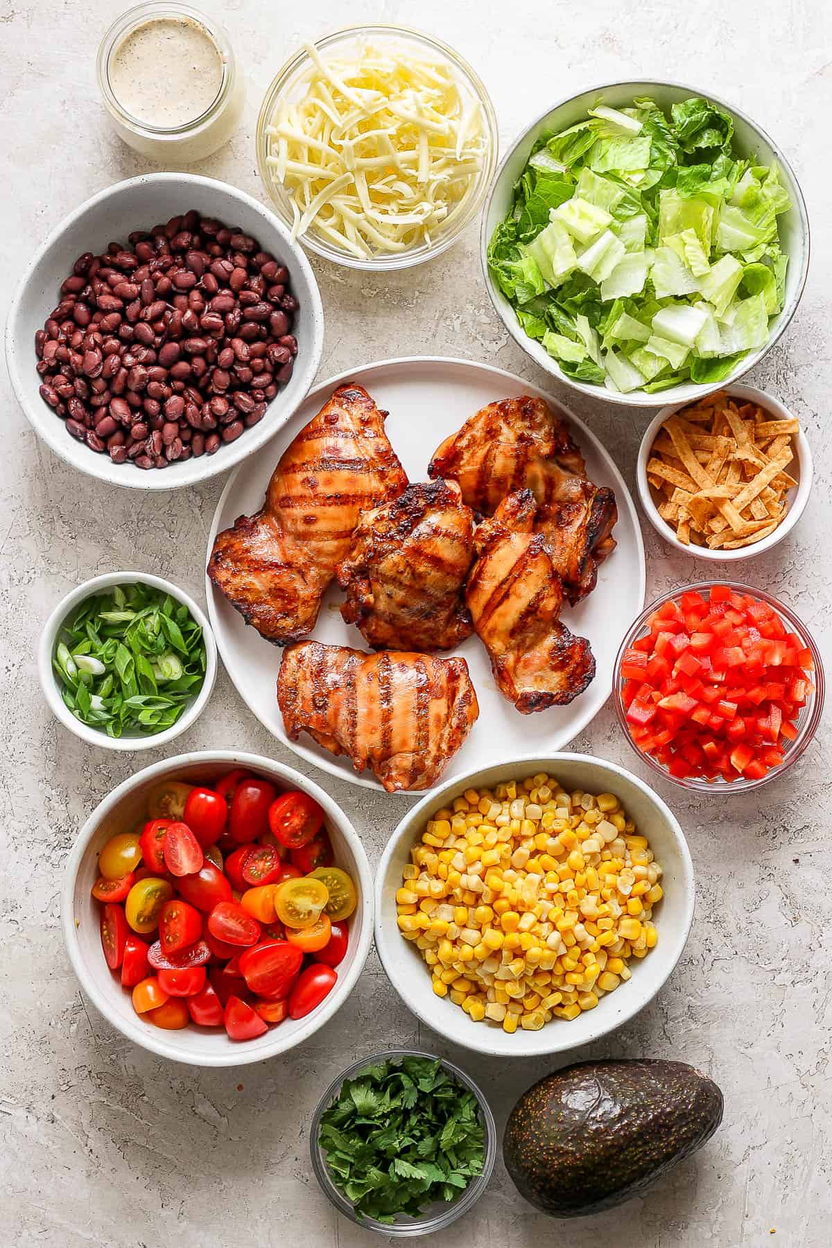 Salad ingredients in separate bowls.