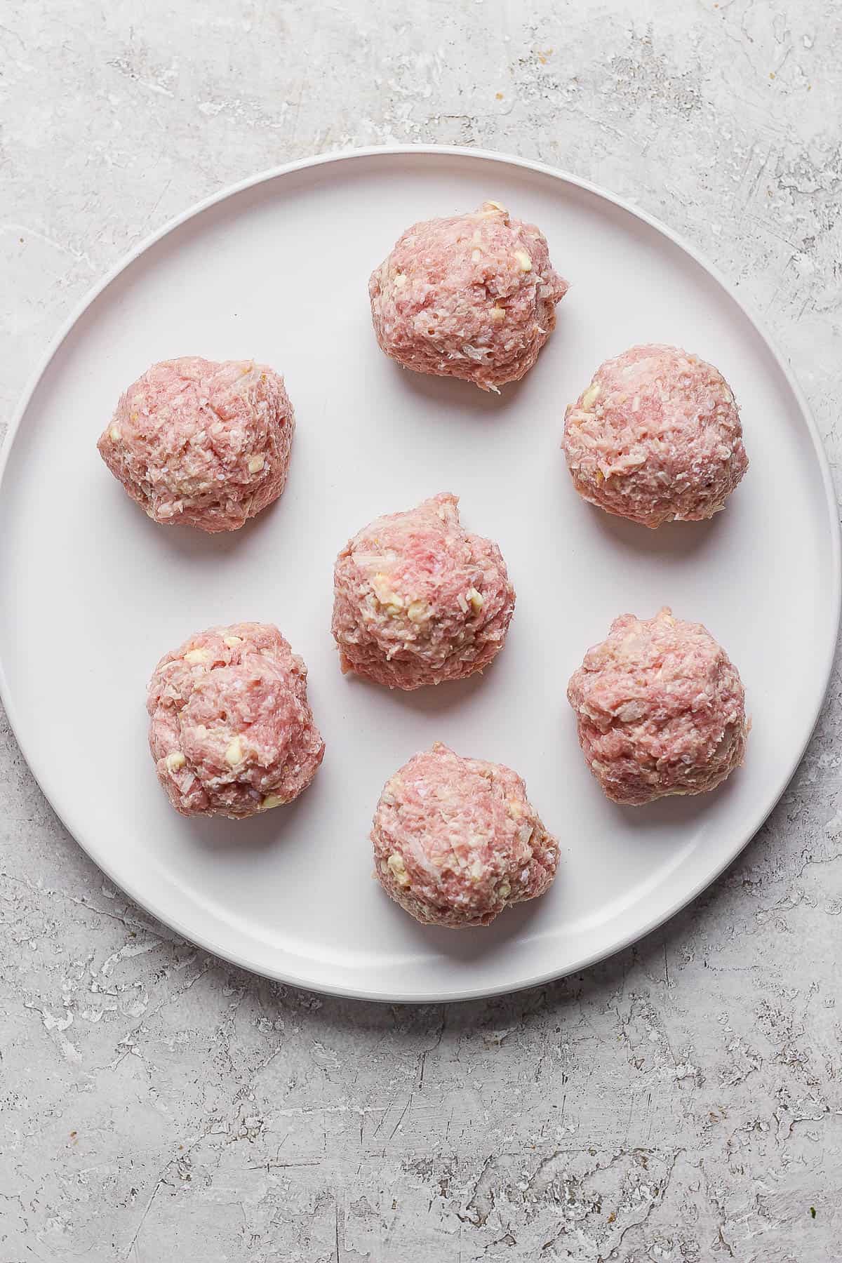 Small turkey burger balls on a white plate.