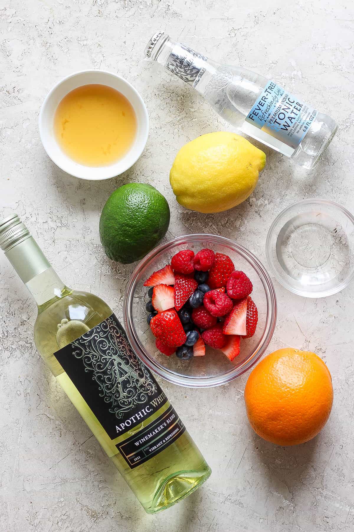 Ingredients for a white wine sangria on the counter.