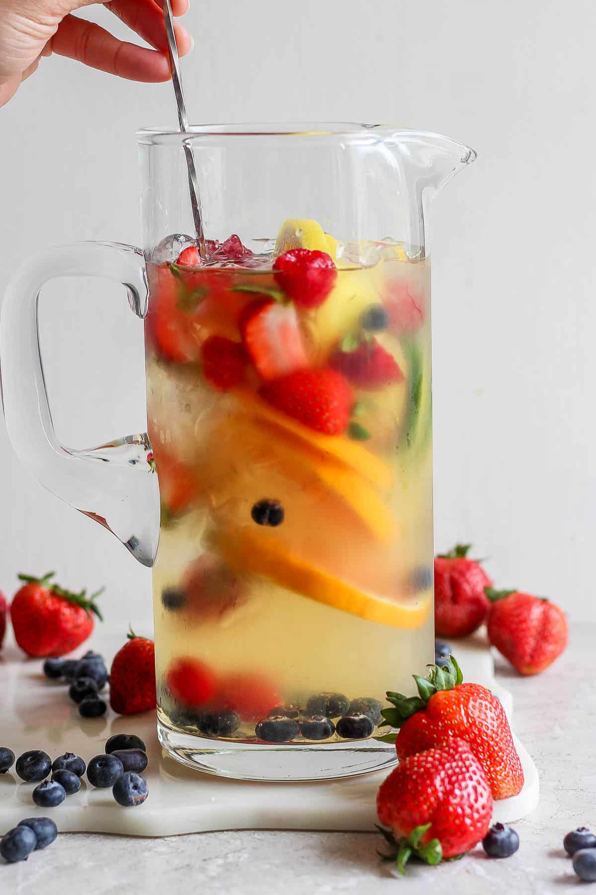 A pitcher of sangria being stirred.