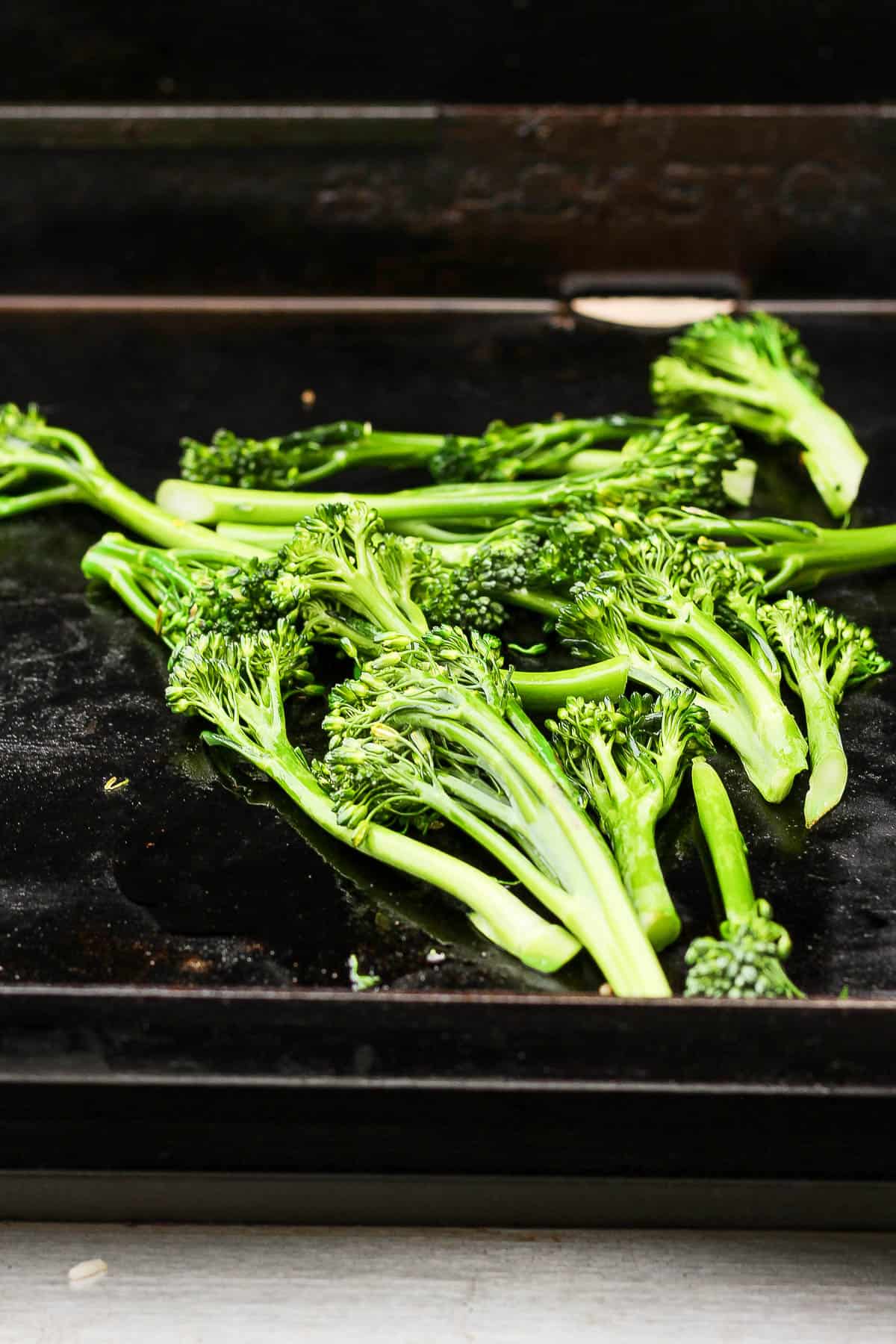 Broccolini cooking on the flat top griddle.