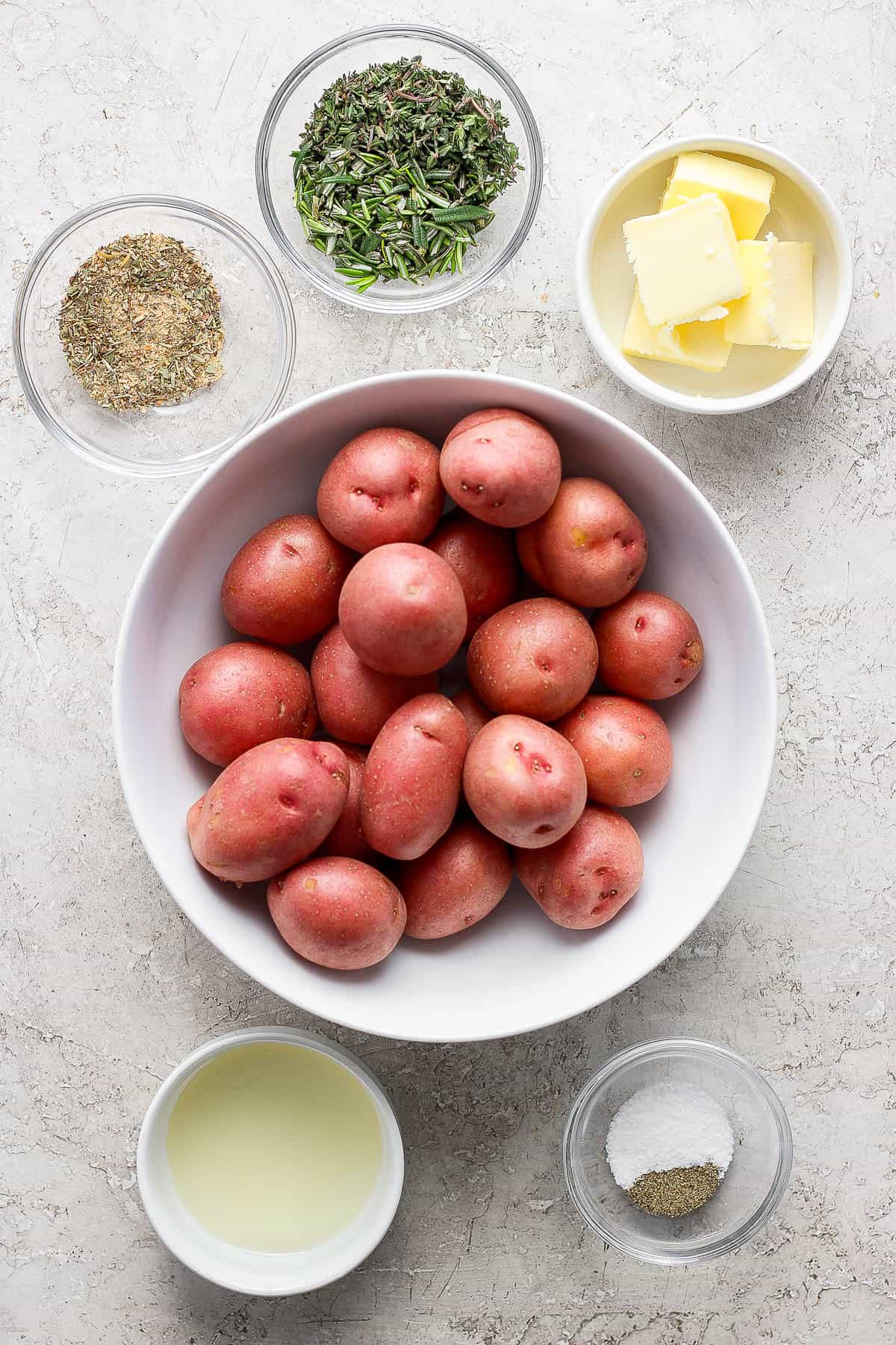 Ingredients for boiled potatoes in separate bowls.