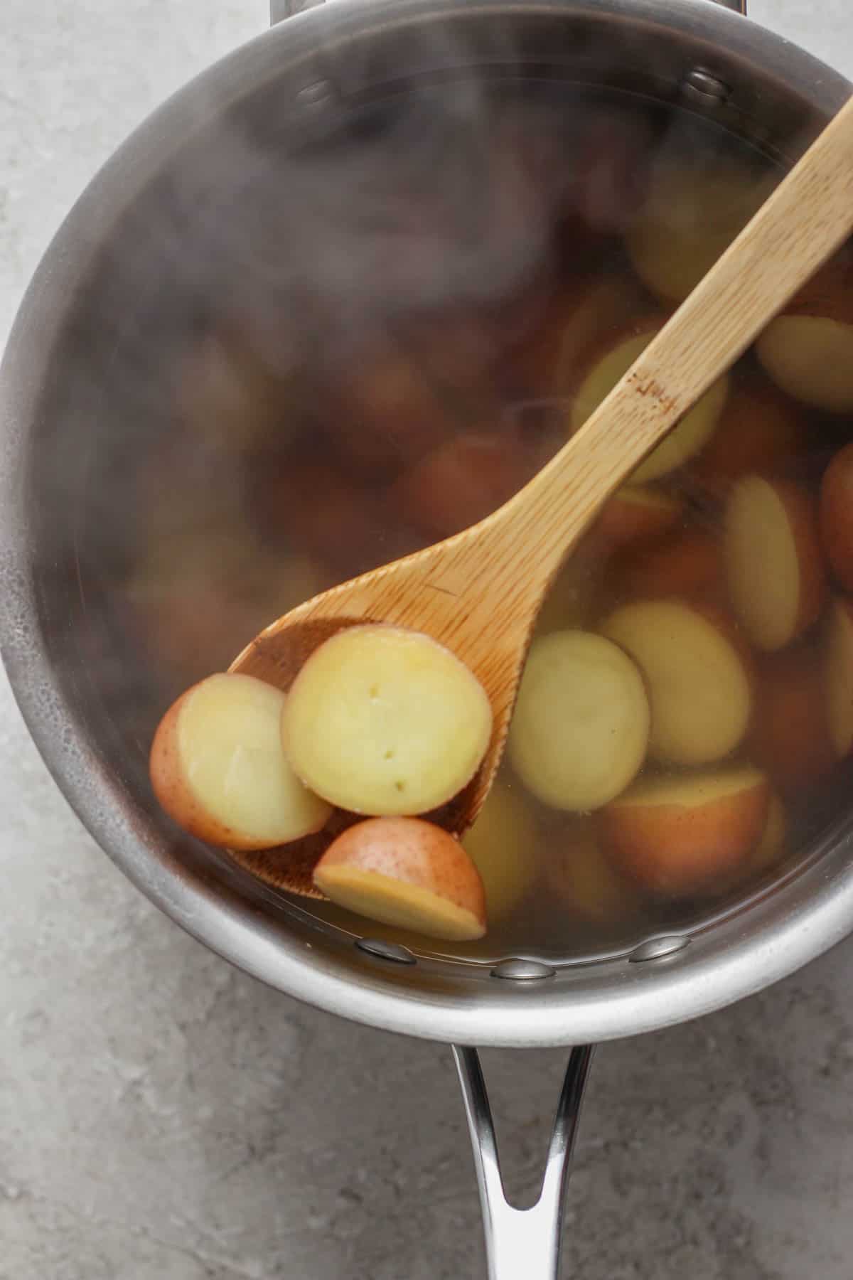 A large pot of potato halves after boiling.