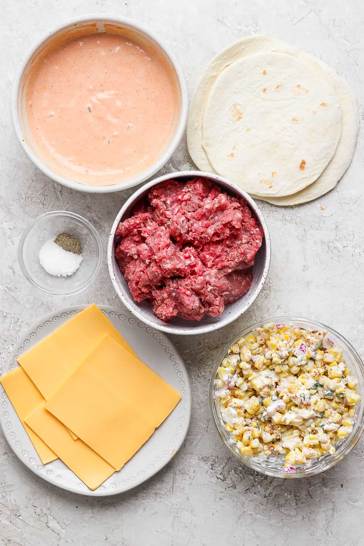 Pieces of Mexican street corn smash burger tacos in separate bowls.