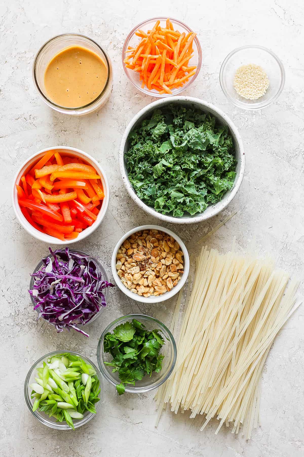 Ingredients for thai peanut noodles in separate bowls.