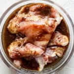 Top down shot of a bowl of chicken thighs sitting in a balsamic chicken marinade.