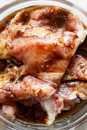 Top down shot of a bowl of chicken thighs sitting in a balsamic chicken marinade.