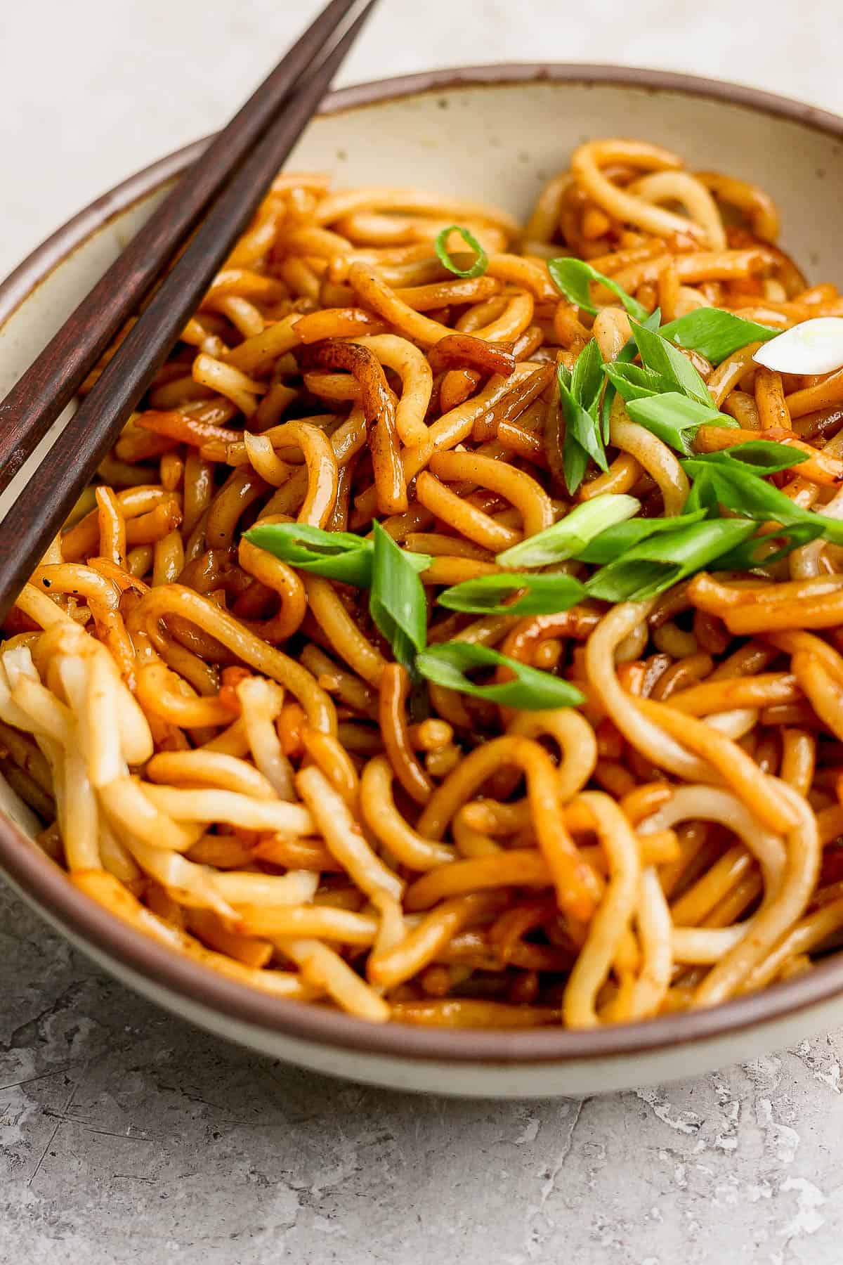 A bowl of garnished hibachi noodles.