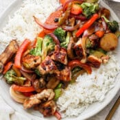 A shallow bowl full of cooked rice and topped with Blackstone stir fry with chicken.
