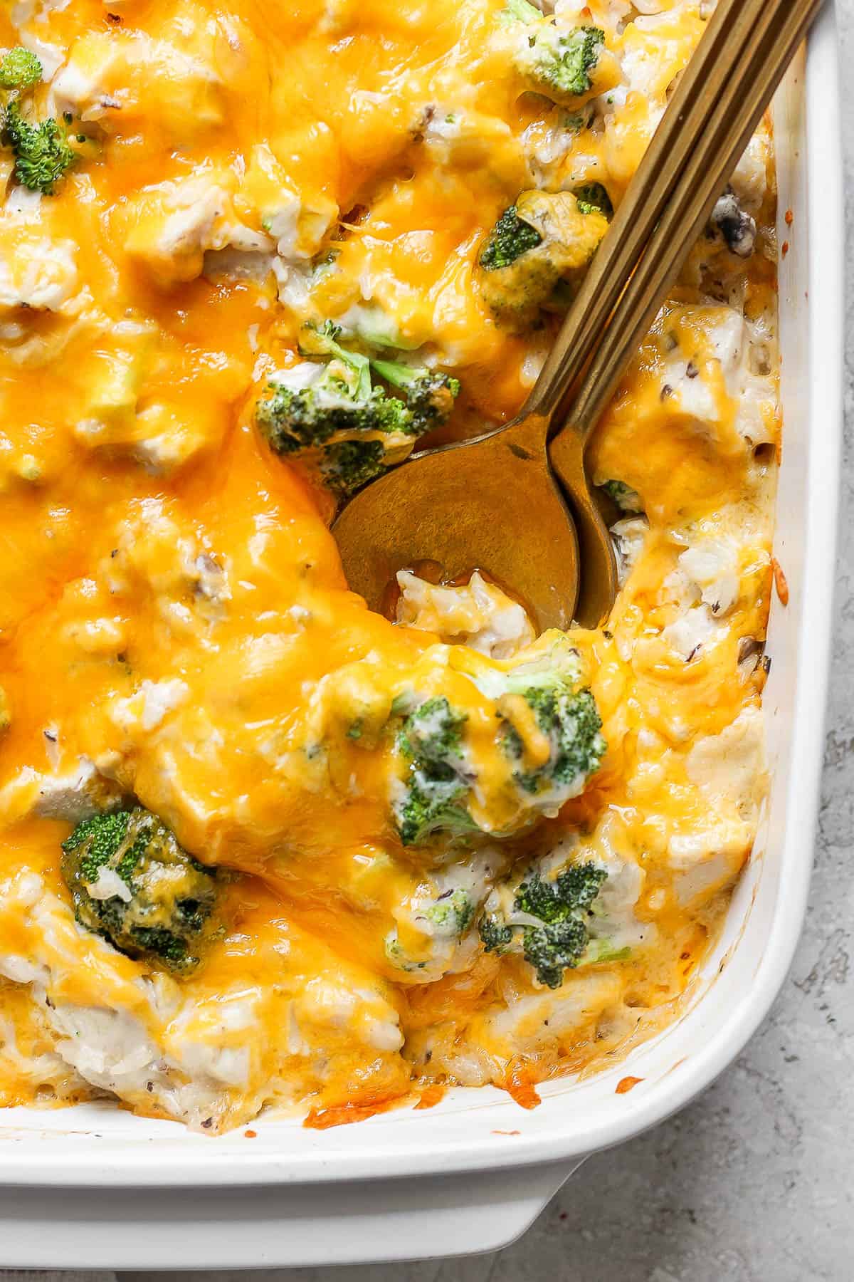 A close up of cheesy broccoli chicken and rice in the casserole dish.