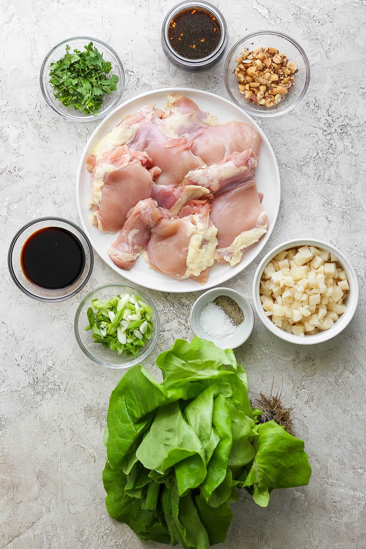 Ingredients for chicken lettuce wraps in separate bowls.