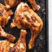 Top down shot of a smoked chicken quarter on a baking sheet.