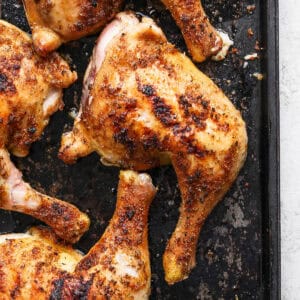 Top down shot of a smoked chicken quarter on a baking sheet.