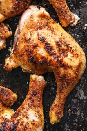 Top down shot of a smoked chicken quarter on a baking sheet.