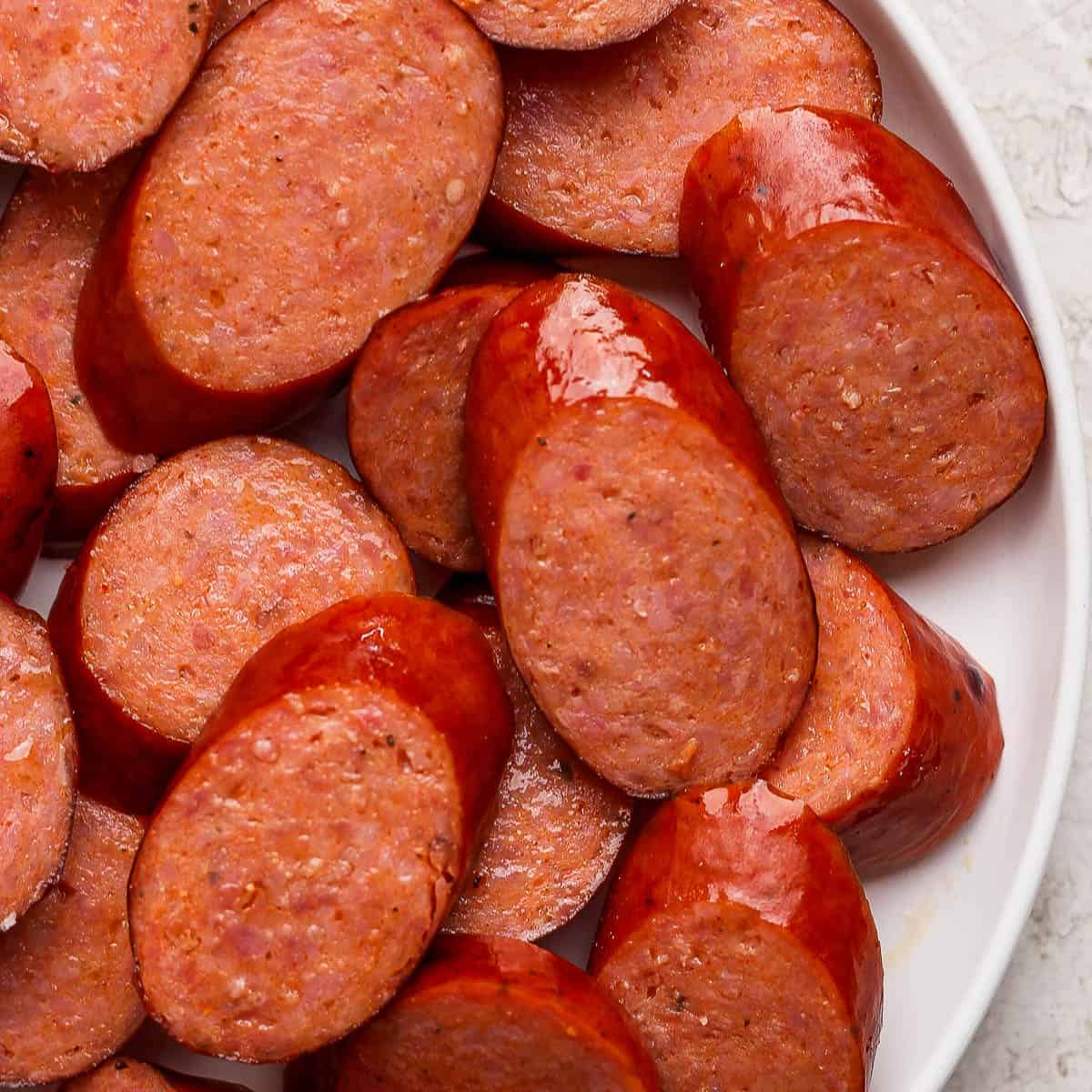 A plate full of sliced smoked sausage.