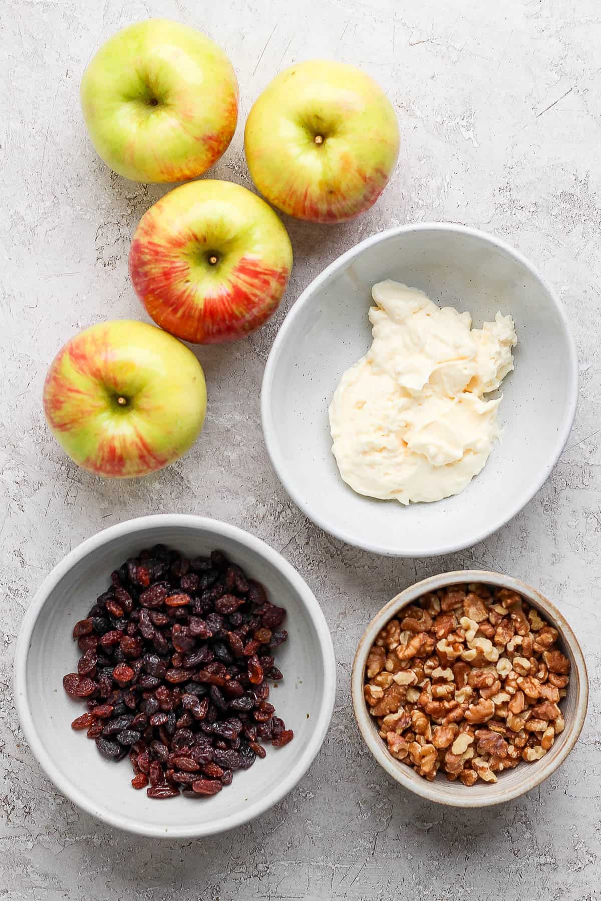 Ingredients for apple salad in separate bowls.