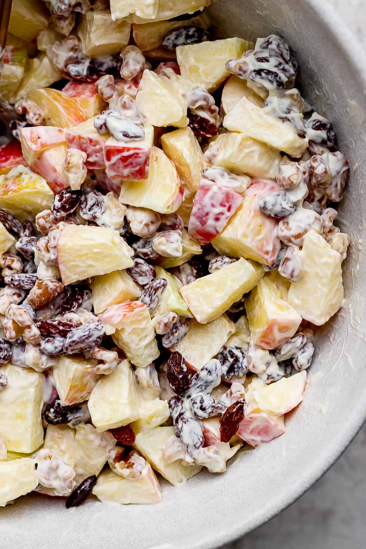 A fully mixed apple salad in a large bowl.