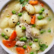 Bowl of chicken gnocchi soup with a spoon sticking out.