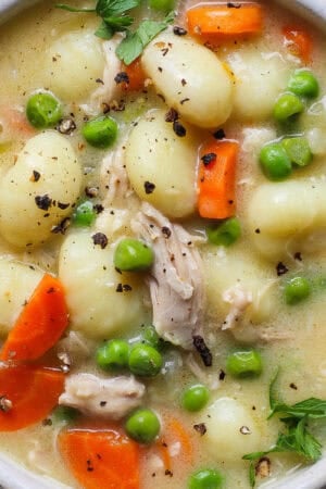 Bowl of chicken gnocchi soup with a spoon sticking out.