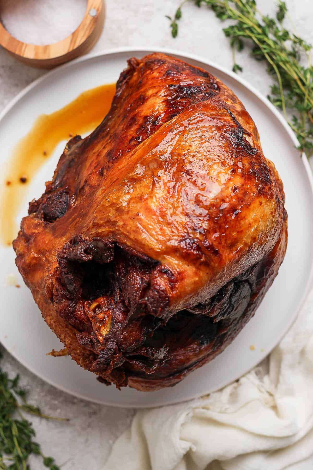 A fully cooked deep fried turkey breast on a white plate.