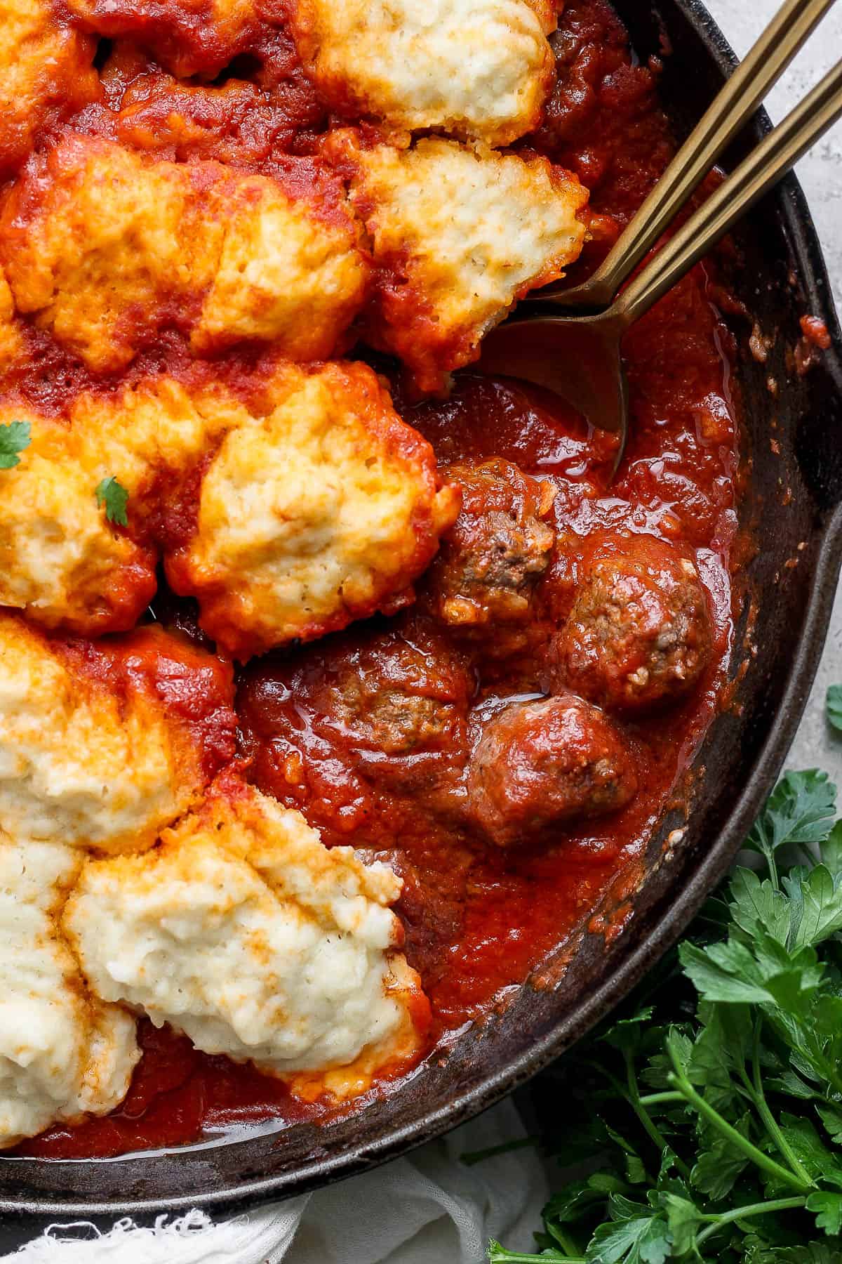 Fully cooked meatballs and dumplings in a skillet.