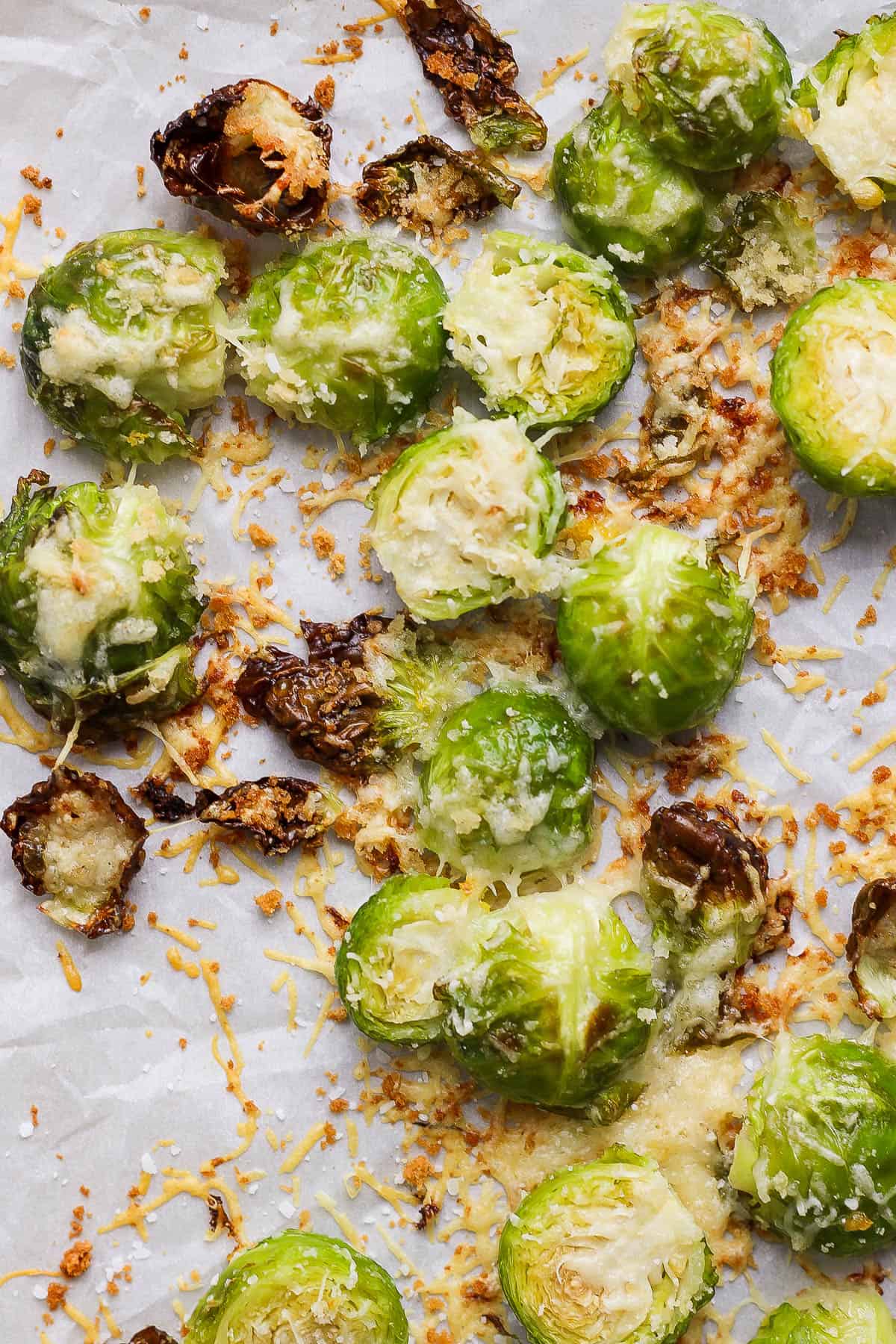 Roasted parmesan brussel sprouts on a parchment lined baking sheet.