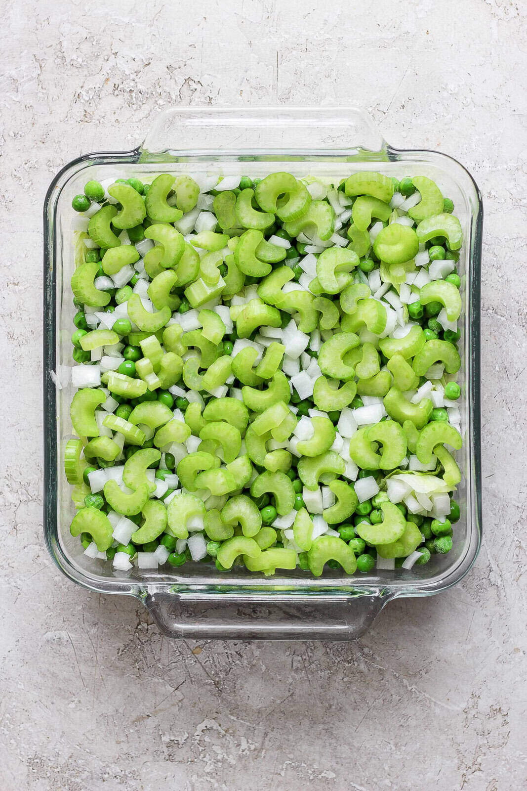 Peas, onions and celery layered on top of the lettuce.