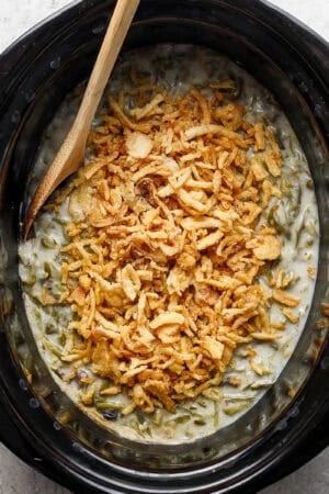 Top down shot of a slow cooker filled with green bean casserole.