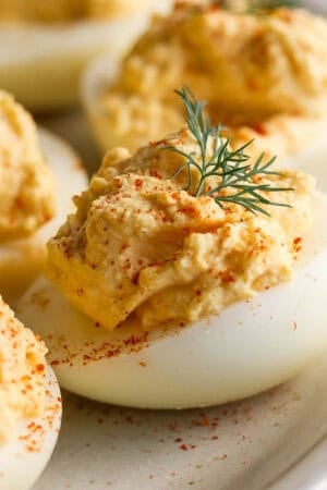 A side shot of a smoked deviled egg with paprika and dill garnish.