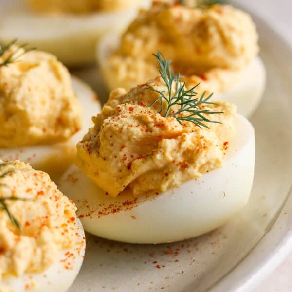 A side shot of a smoked deviled egg with paprika and dill garnish.