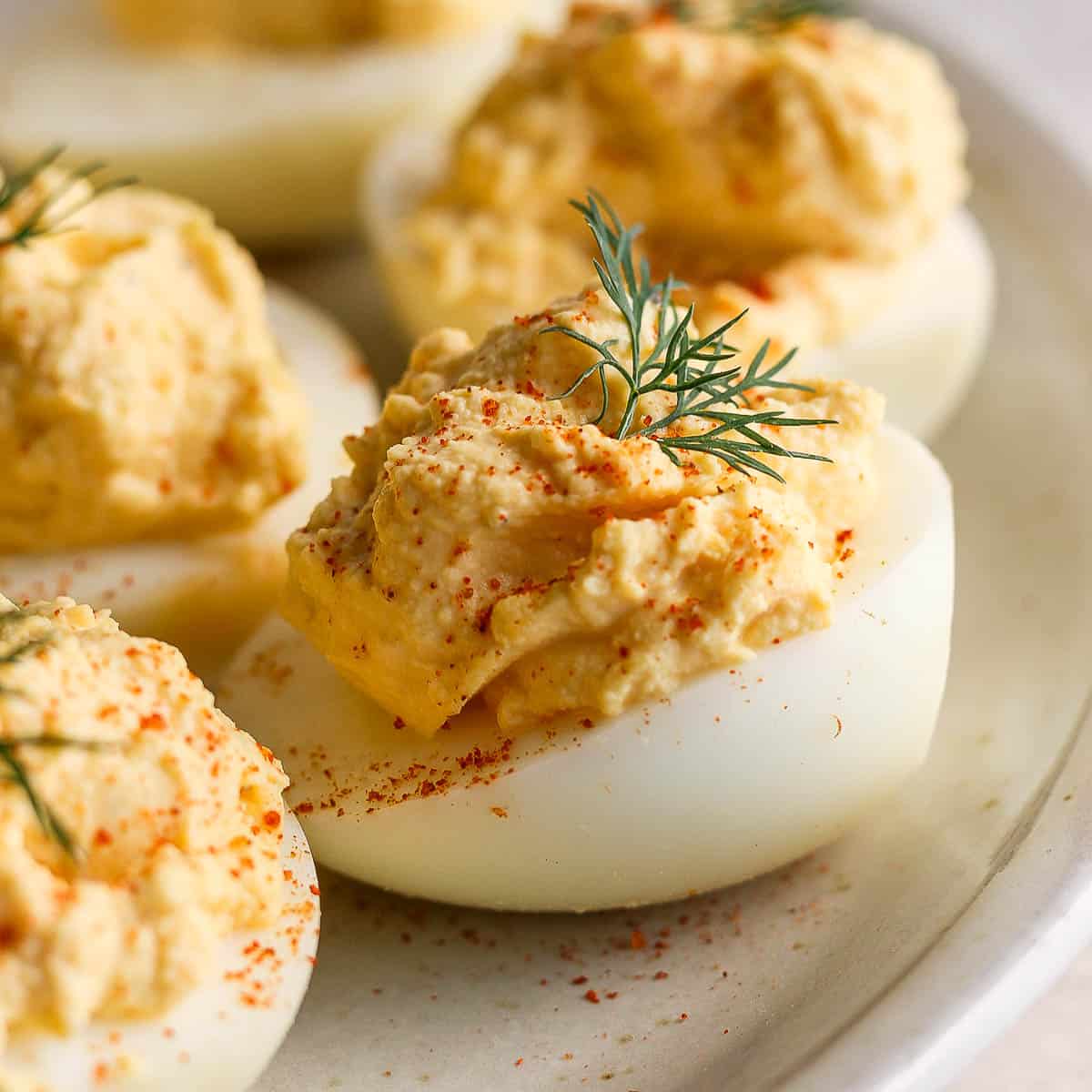 A side shot of a smoked deviled egg with paprika and dill garnish.