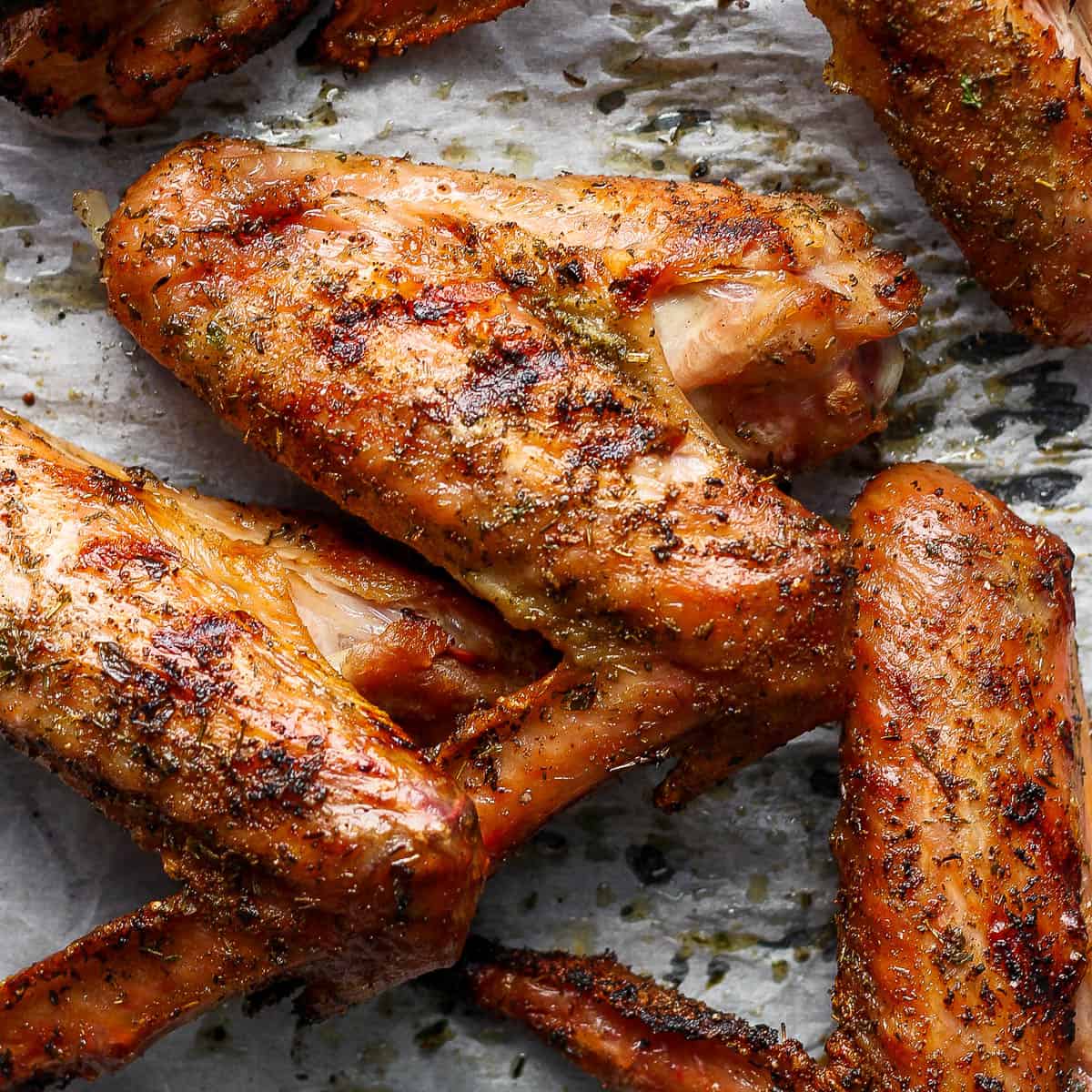 Top down shot of a smoked turkey wing a parchment-lined baking sheet.