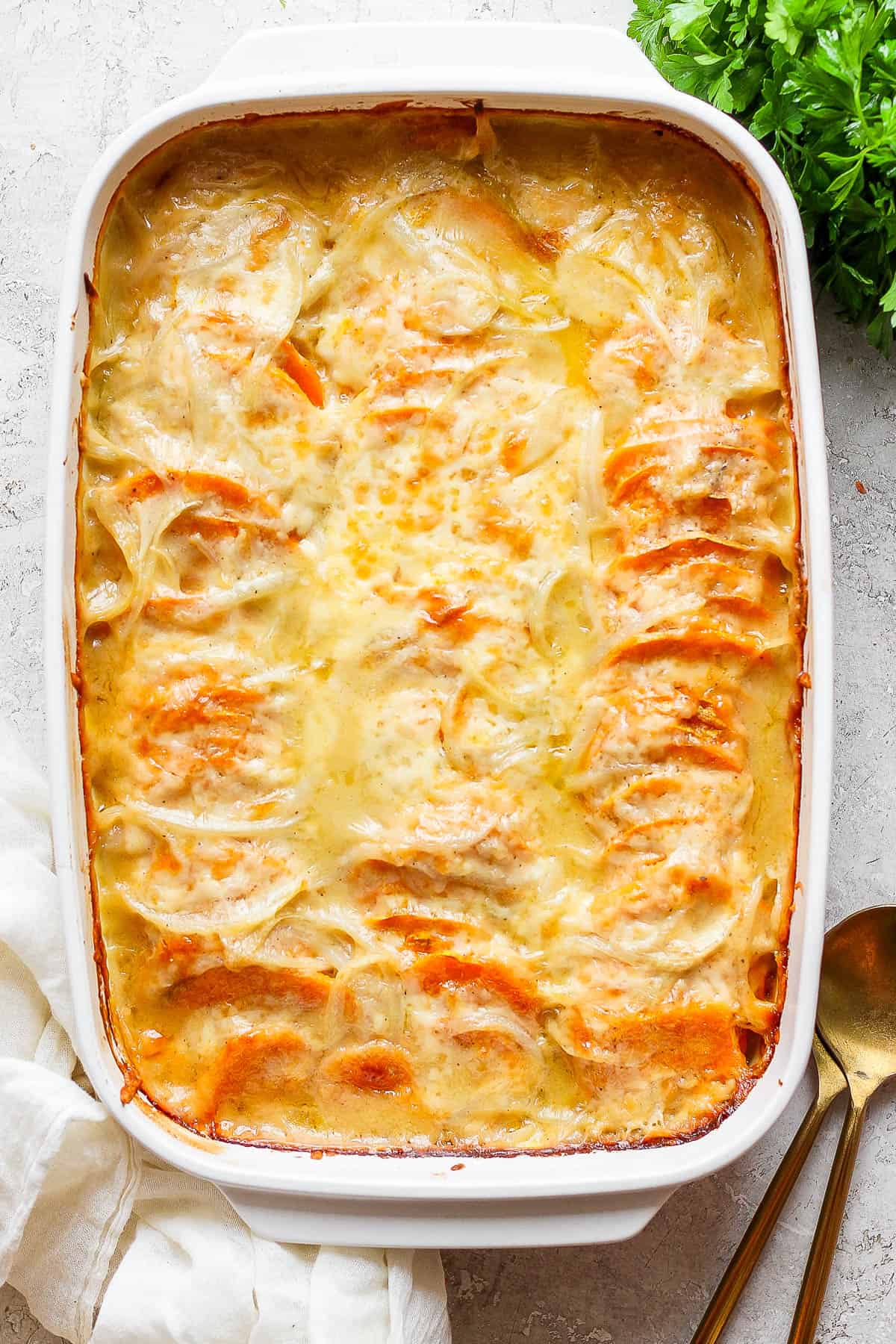 Fully baked sweet potato au gratin in a casserole dish.