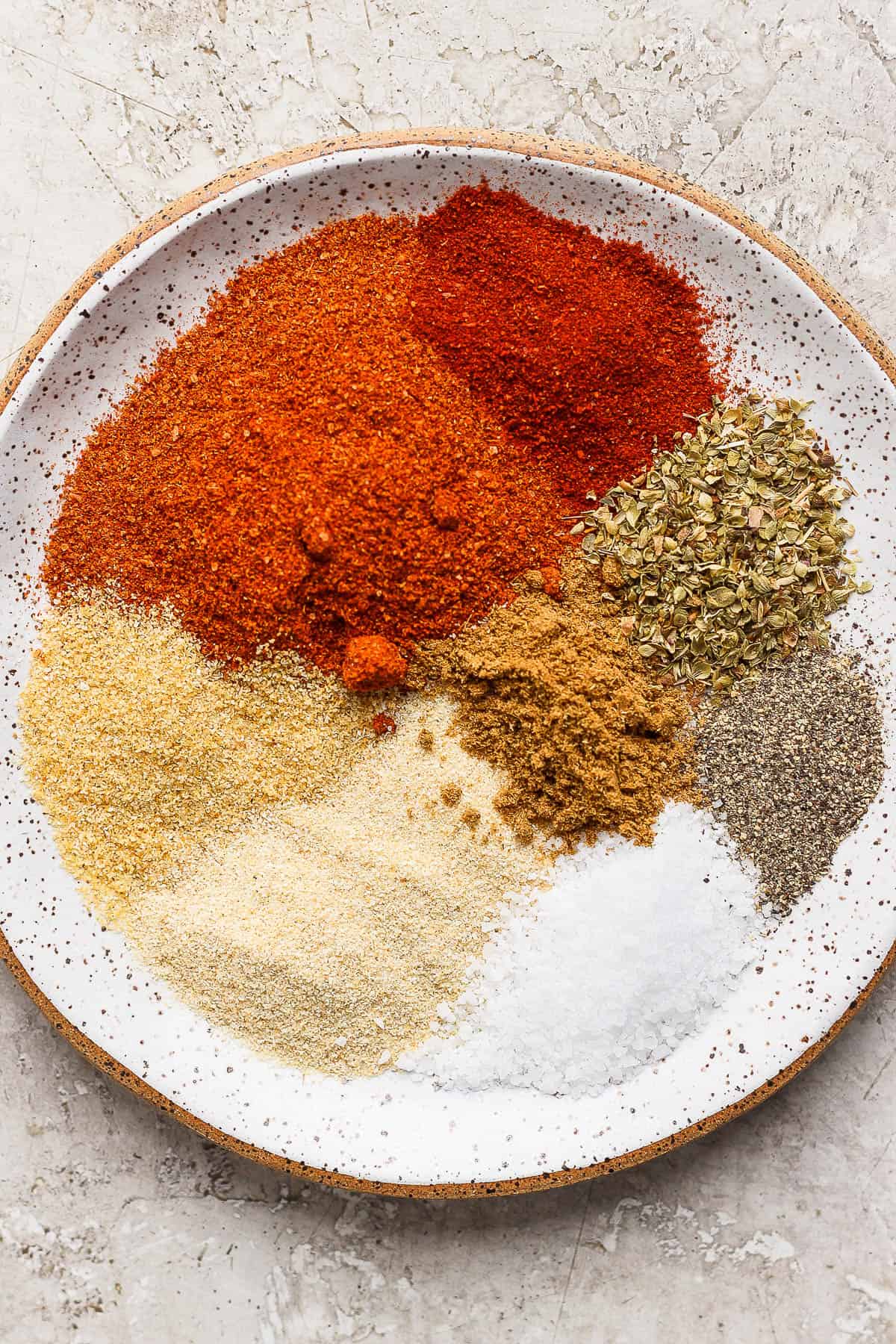 Spices for homemade taco seasoning on a plate.