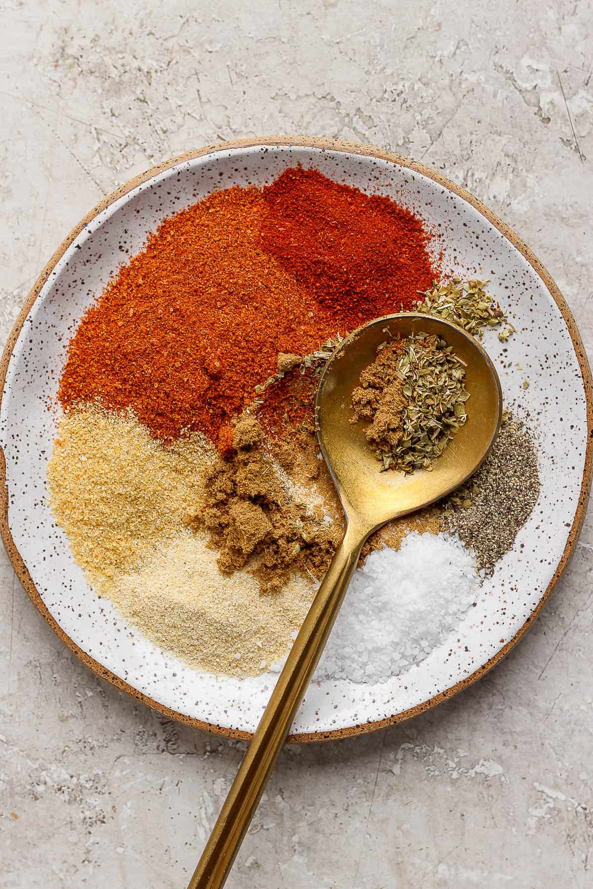 Taco seasoning mixed slightly on a plate with a spoon.