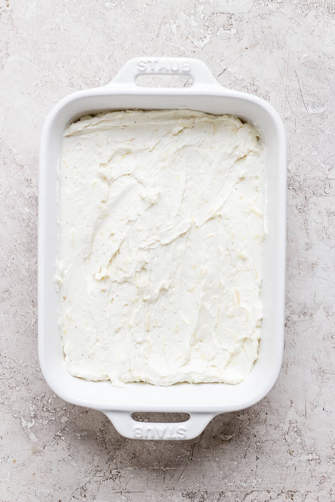 Baked goat cheese dip in a casserole dish.