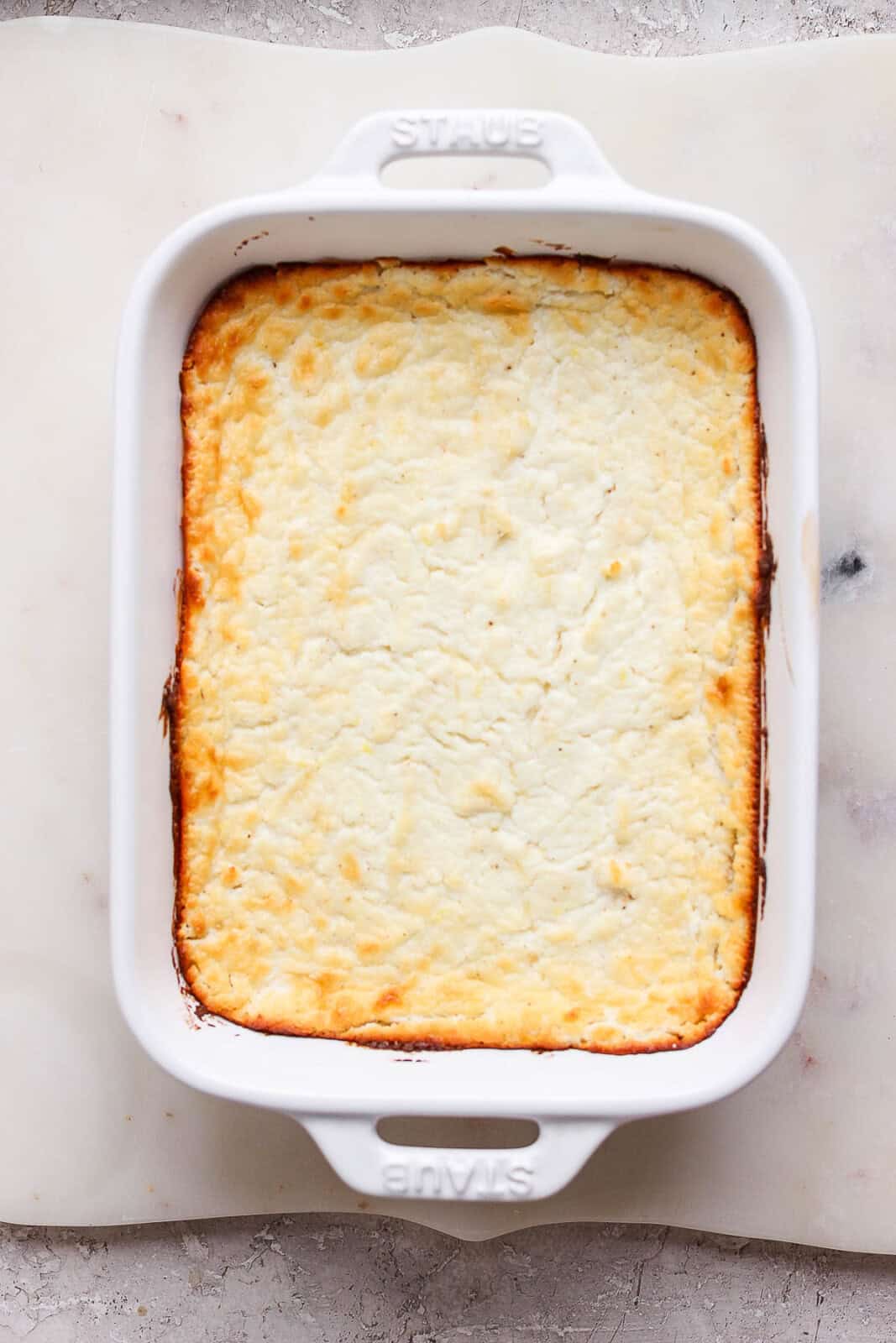 Baked goat cheese dip baked in a casserole dish.