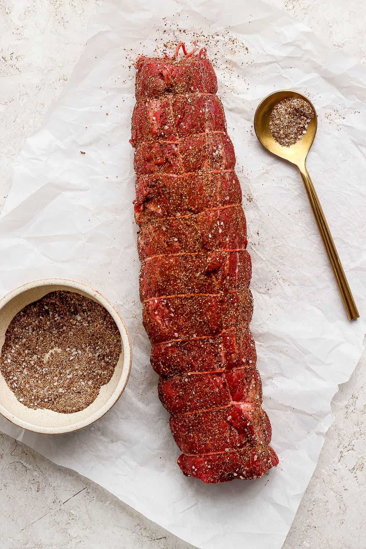 A wrapped beef tenderloin coated in  the dry rub seasoning.