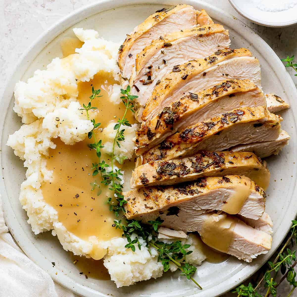 Plate of sliced Instant Pot Turkey Breast, mashed potatoes and gravy.