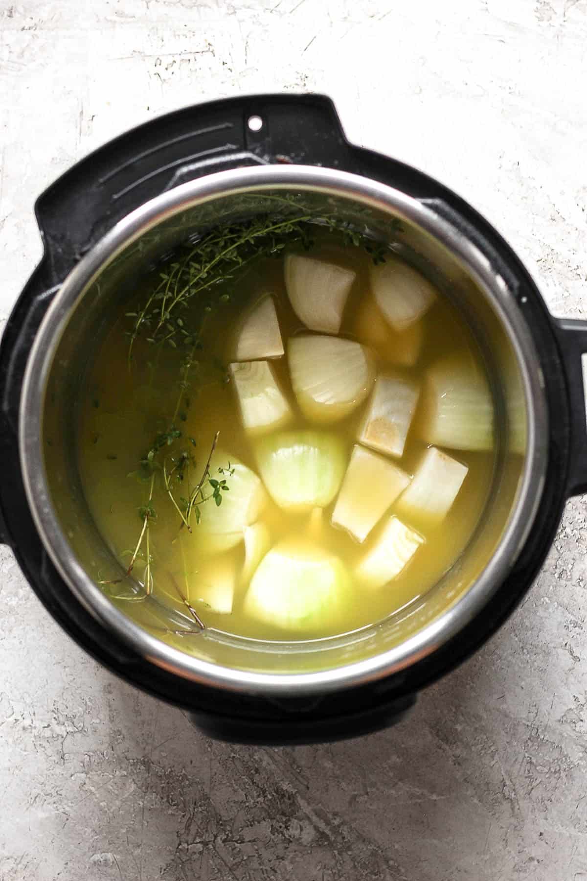 Broth, orange juice, white wine, onion, and fresh thyme in the pressure cooker.