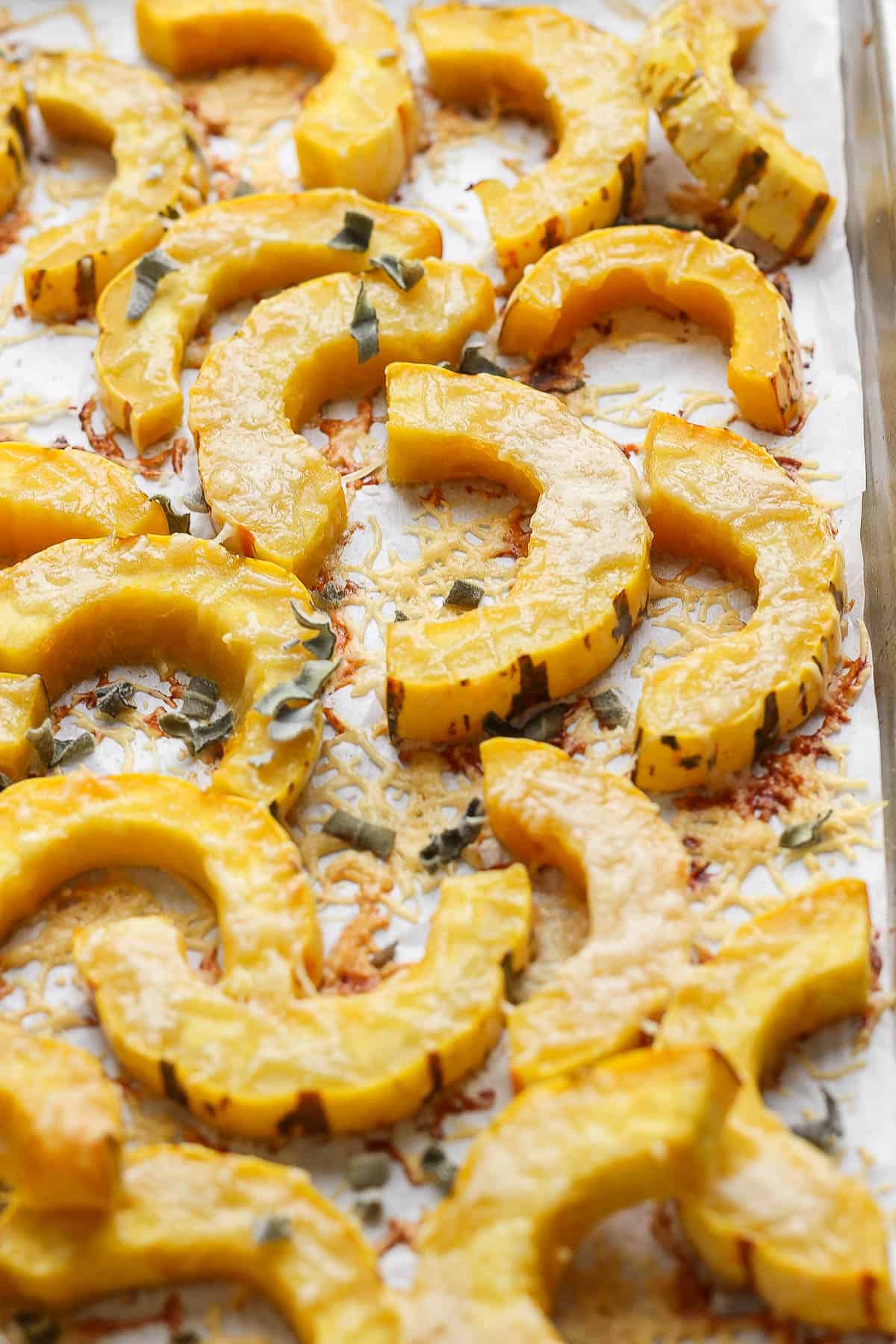 Roasted delicata squash on a baking sheet.