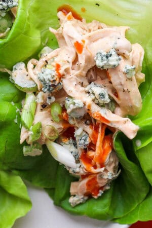 Some Buffalo Ranch Chicken Salad on some butter lettuce with some blue cheese, green onion and buffalo sauce.