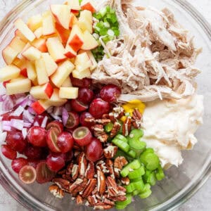 Top down shot of a bowl filled with all the ingredients for chicken salad with grapes, but unmixed.