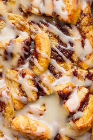 A casserole pan filled with a cinnamon roll casserole with frosting on top.