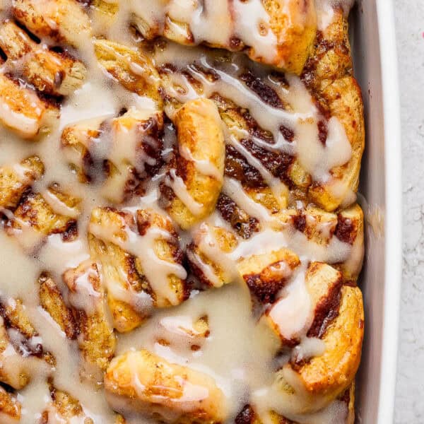 A casserole pan filled with a cinnamon roll casserole with frosting on top.