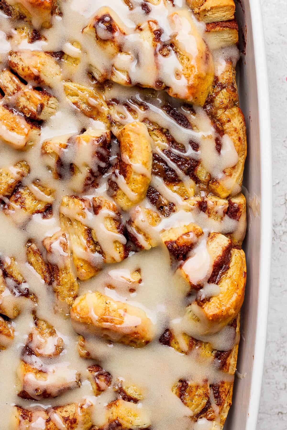 The cinnamon roll casserole covered in icing.