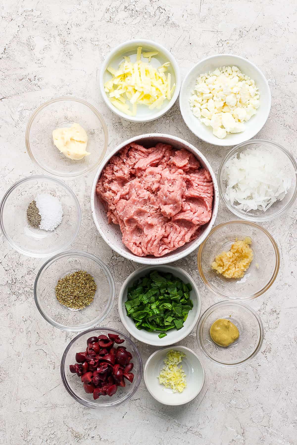 Ingredients for greek turkey burgers in separate bowls.