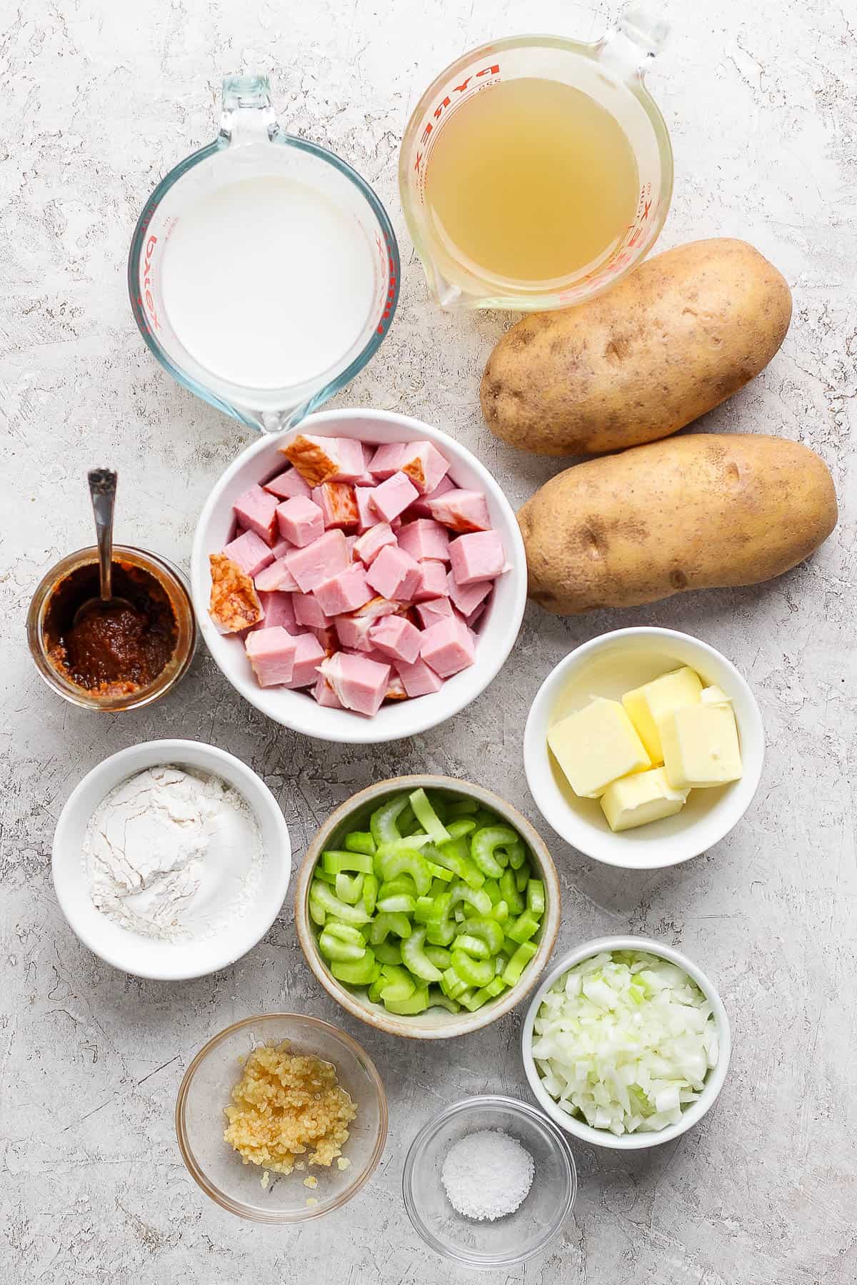 Ingredients for ham potato soup in separate bowls.