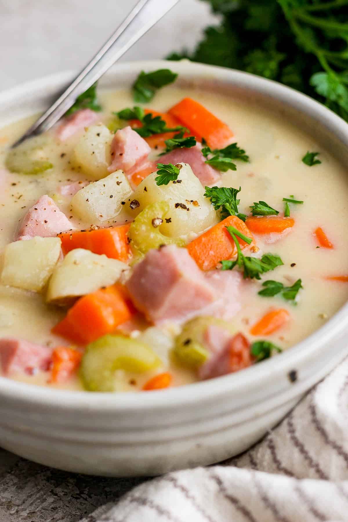 Ham potato soup in a white bowl.